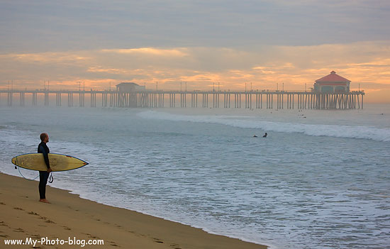 A surfer checking out the early morning waves, Huntington Beach, California.