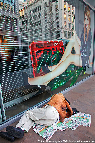 A homeless person sleeps on a sidewalk in downtown San Francisco, California.